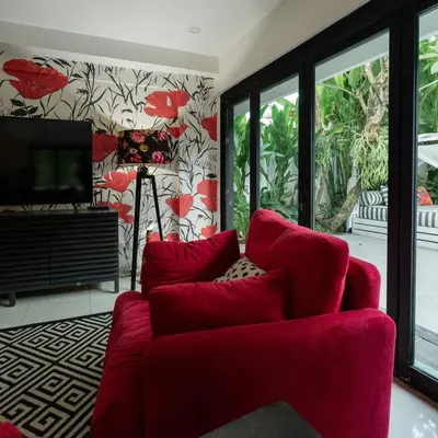 a living room with a red couch and a tv at Villa Drupadi 16 in Seminyak