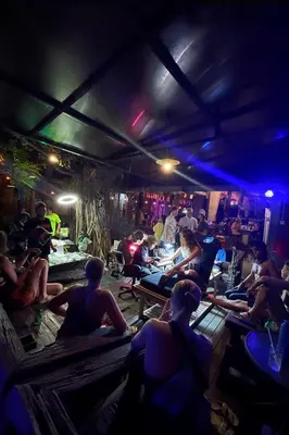 a group of people sitting on benches in a room at Da Housetel Kuta in Kuta