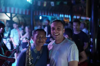 two men standing next to each other with a saxophone at Da Housetel Kuta in Kuta