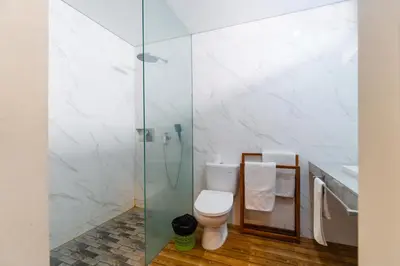 a bathroom with a toilet and a glass shower at Villa C31 Seminyak in Seminyak