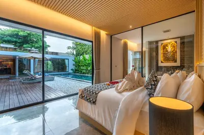a bedroom with a bed and a view of a pool at Villa Narda Seminyak by Nagisa Bali in Legian