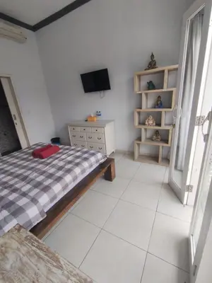 a bedroom with a bed and a tv in it at Deluxe room near seminyak beach in Seminyak