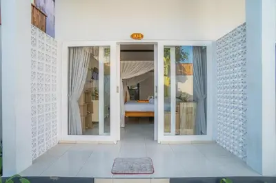 a white room with a bedroom with a bed at Deluxe room near seminyak beach in Seminyak