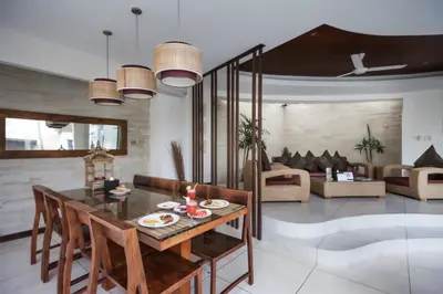 a living room with a table and chairs and a couch at Villa K Seminyak by Premier Hospitality Asia in Seminyak