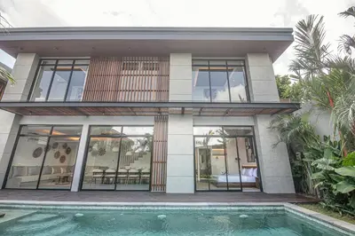 a house with a swimming pool in front of it at Stunning 5BR Canggu Villa 400m from the Beach in Canggu