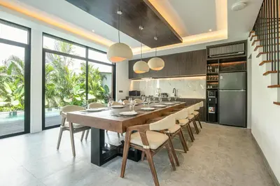 a large kitchen with a long table and chairs at Serene 5-Bedroom Villa 400 m from Batu Bolong in Canggu