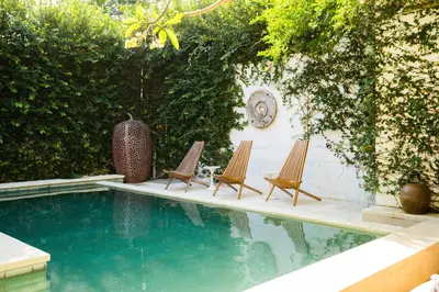 two chairs sitting next to a swimming pool at Anam Khaya - Brand New Villa, Walk to Seminyak Beach in Seminyak