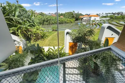 a view from the balcony of a house with a swimming pool at Modern 2BR Design Haven with green views, rooftop in Kerobokan