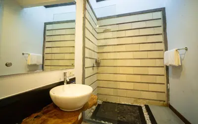 a bathroom with a sink and a mirror at Kayu Suar Bali Luxury Villas & Spa in Sanur