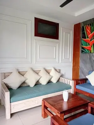 a couch with pillows and a table in a room at Casa Green Kori in Kerobokan