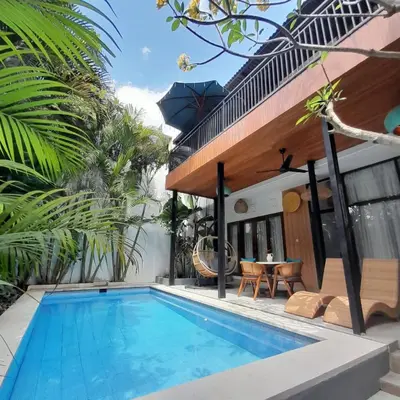 a villa with a swimming pool and a house at Casa Green Kori in Kerobokan