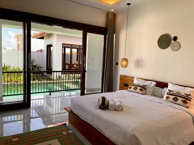 a bedroom with a large bed and a balcony at Chic Villa at Kubu Taullan 3B in Kerobokan