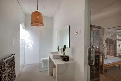 a white bathroom with a sink and a toilet at Villa Bohème Umalas in Canggu