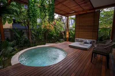 a hot tub on a wooden deck with a patio at Kayunida - Charming 1BR Wooden Villa in Seminyak in Seminyak