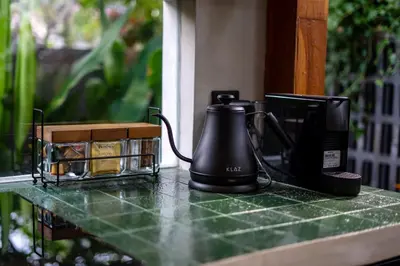 a coffee maker sitting on a counter next to a box of cookies at Kayunida - Charming 1BR Wooden Villa in Seminyak in Seminyak