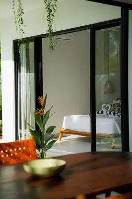 a room with a table with a bed in the background at Rooftop Villa Elegant 4BR Retreat in Umalas in Kerobokan