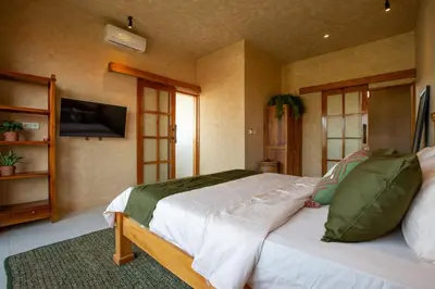 a bedroom with a large bed and a television at Casa Ombak in Kerobokan