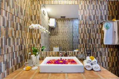 a bathroom with a bath tub with flowers in it at Villa Anvira in Seminyak