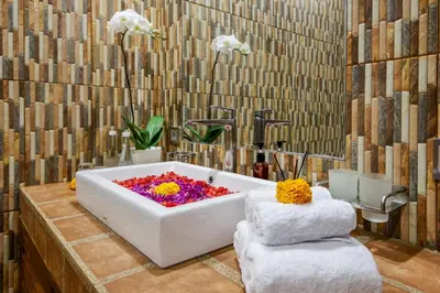 a bathroom with a bath tub with flowers in it at Villa Anvira in Seminyak