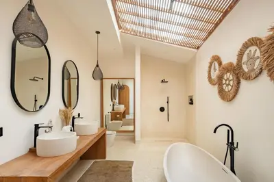 a bathroom with two sinks and two mirrors at Villa Nusa in Canggu