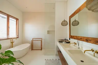 a bathroom with a tub and a sink and a mirror at Villa Nusa in Canggu