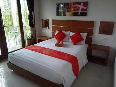 a bedroom with a bed with a teddy bear on it at Pondok Sutya in Kuta