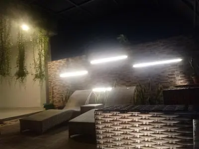 a room with a couch and lights on a brick wall at Pondok Sutya in Kuta