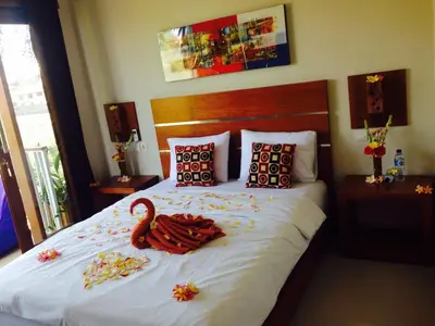 a bedroom with a bed with a swan on it at Pondok Sutya in Kuta