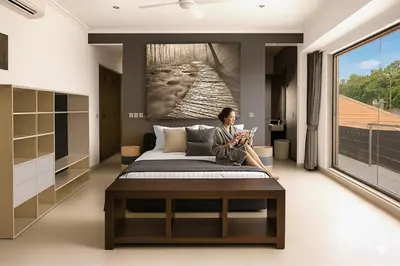 a woman sitting on a bed in a room with a large window at Villa Avrora Batubelig in Canggu
