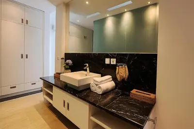 a bathroom with a sink and a black counter at Villa Avrora Batubelig in Canggu