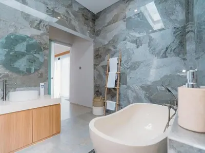 a bathroom with a tub and a sink and a mirror at Arjuna Villa in Seminyak