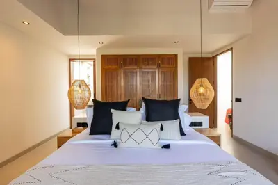 a bedroom with a large bed with blue and white pillows at 2BR Modern Mediterranean Villa Near Nook in Badung