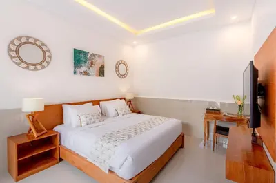 a bedroom with a bed and a desk and a television at Casa Amore Villa in Berawa Beach - Canggu in Canggu