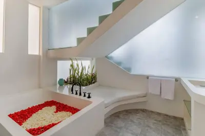 a white bathroom with a sink and stairs at Berawa -Ocean View 5 Bed, Walk to Beach, Sleeps 10 in Canggu