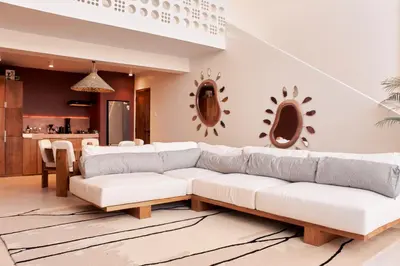 a living room with a white couch and a kitchen at Gate 11 Apartments in Denpasar