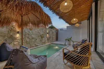an outdoor pool with a chair and a hammock at Tropical and Minimalist 2bd Umalas Villa with Private Pool in Canggu