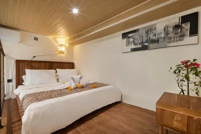 a hotel room with a bed and a night stand at Cozia Living in Jimbaran