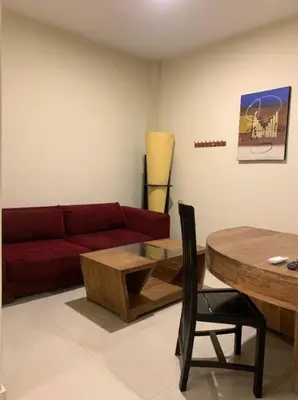 a living room with a red couch and a table at Marinos Place Legian in Legian