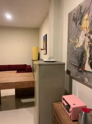 a room with a refrigerator and a painting on the wall at Marinos Place Legian in Legian