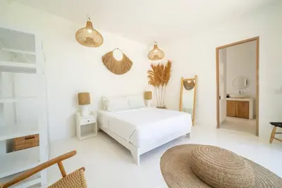 a white bedroom with a bed and a mirror at Villa Amie Elegant 5BR with Pool & Rooftop Umalas in Canggu