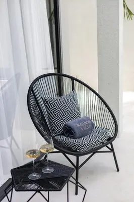 a wicker chair with two glasses of wine at Brand New Luxury Design Villa by Amare Villas 4 in Badung