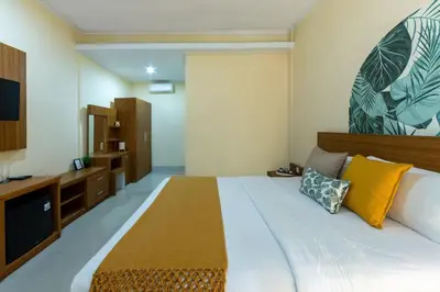 a bedroom with a large bed with yellow pillows at Cove Raddeyapa in Canggu