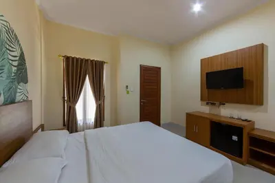 a bedroom with a bed and a flat screen tv at Cove Raddeyapa in Canggu