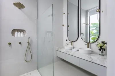a bathroom with two sinks and two mirrors at Brand New Luxury Design Villa by Amare Villas 2 in Badung