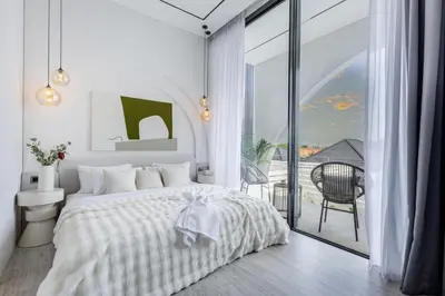 a white bedroom with a bed and a balcony at Brand New Luxury Design Villa by Amare Villas 2 in Badung