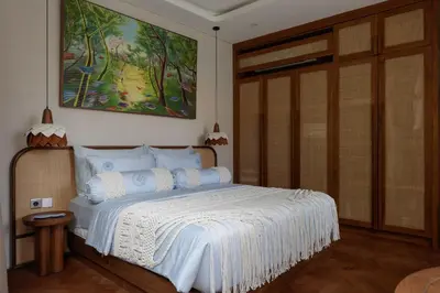 a bedroom with a bed with a painting on the wall at Lavanya Villa Berawa beach in Canggu