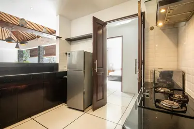 a kitchen with a refrigerator and a stove at Vase 2BR Villa Seminyak in Seminyak