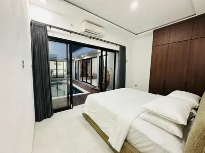 a bedroom with a large bed and a large window at Athalia Villa Seminyak in Seminyak