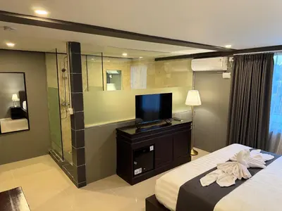a hotel room with a bed and a television at Kooters Guesthouse Bali in Legian