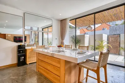 an open kitchen with a large island with white countertops at Modern 3bd Tropical Villa with Pool in Central Umalas in Canggu